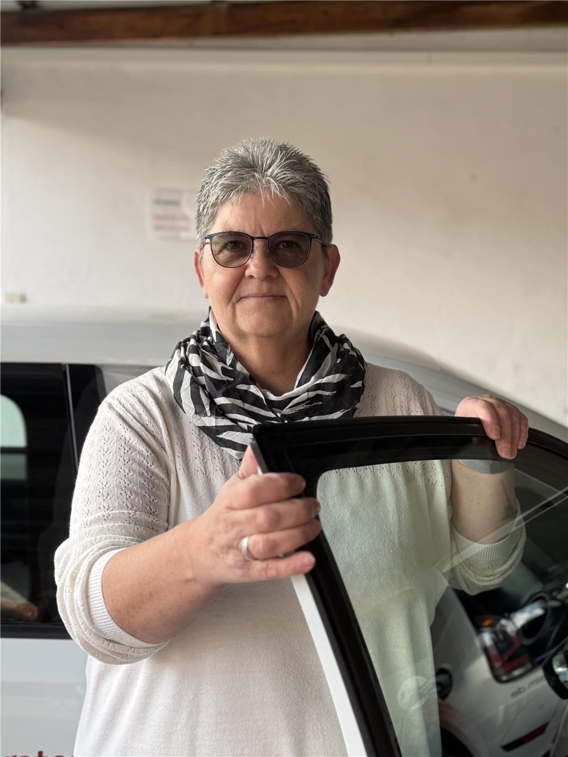Eine Frau steht in einer offenen Fahrertür