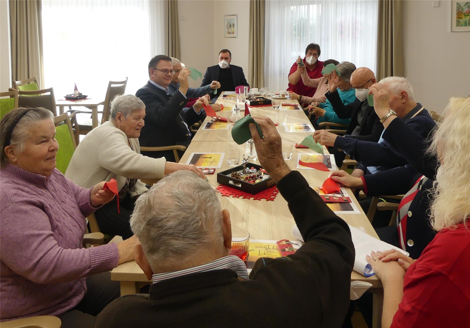 Gäste der Tagespflege Bad Abbach spielen zusammen mit Bürgermeister Doktor Benedikt Gründewald gemeinsame am langen Tisch