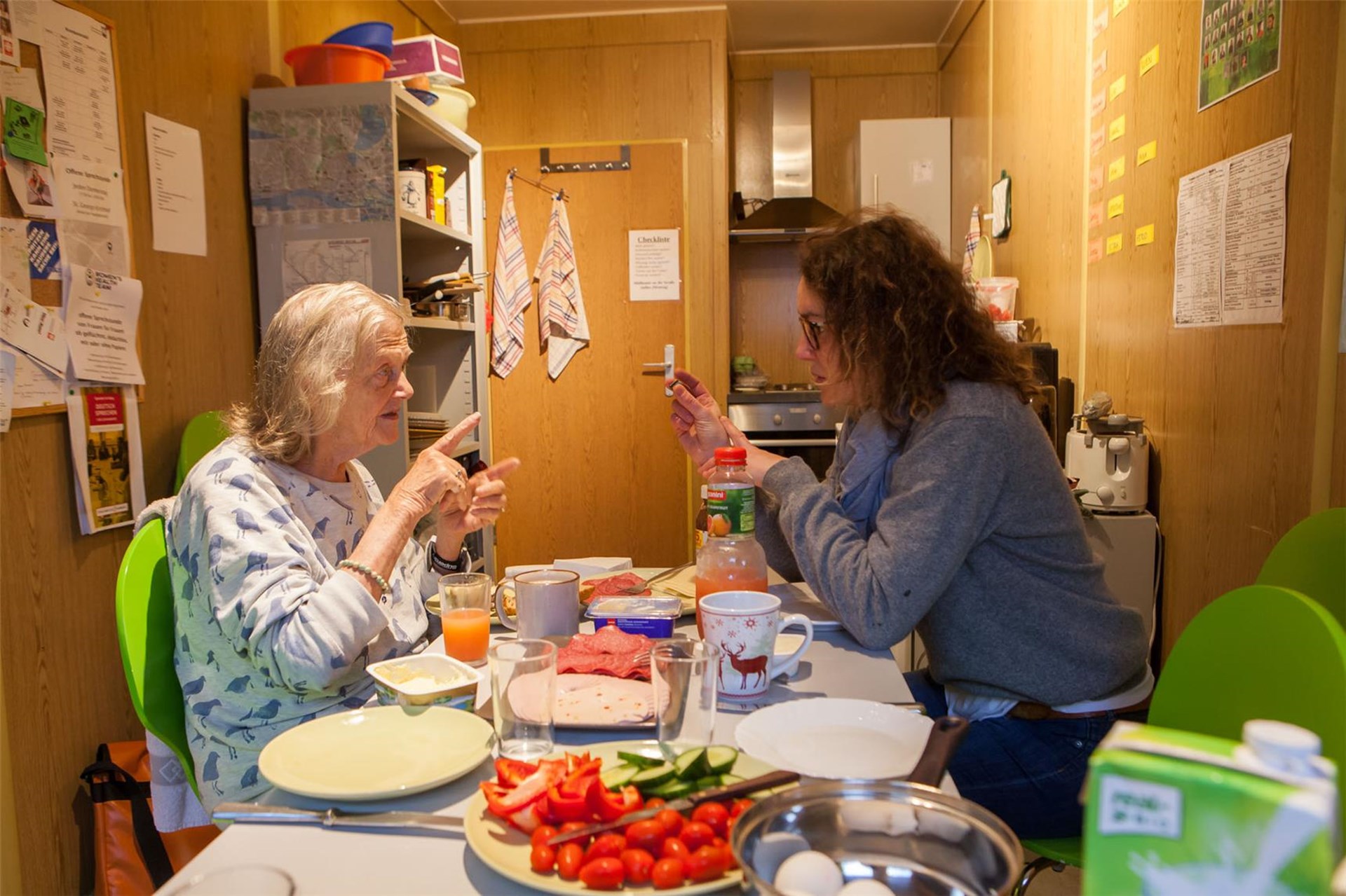 ältere Frau im Gespräch mit engagierter Studentin beim Sonntagsfrühstück
