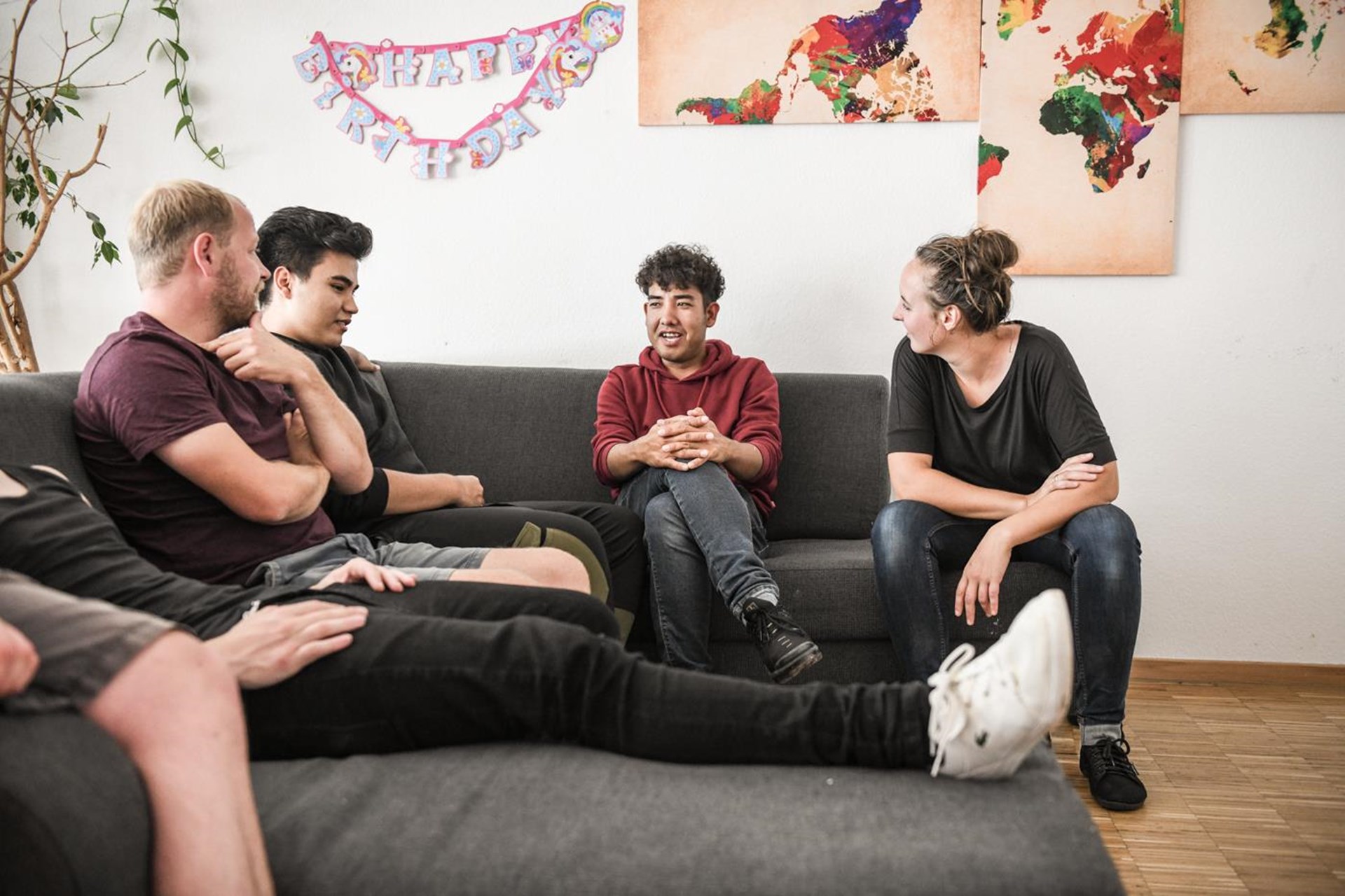 Junge Menschen sitzen am Sofa, und sprechen 